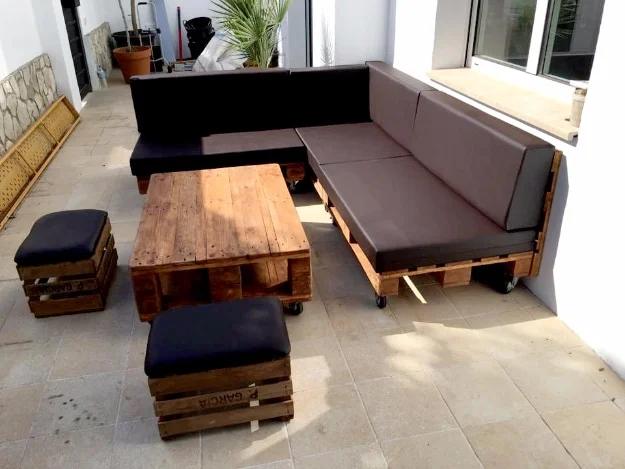 Pallet sectional sofa with brown cushions along a window wall, with a pallet coffee table and two crate ottomans