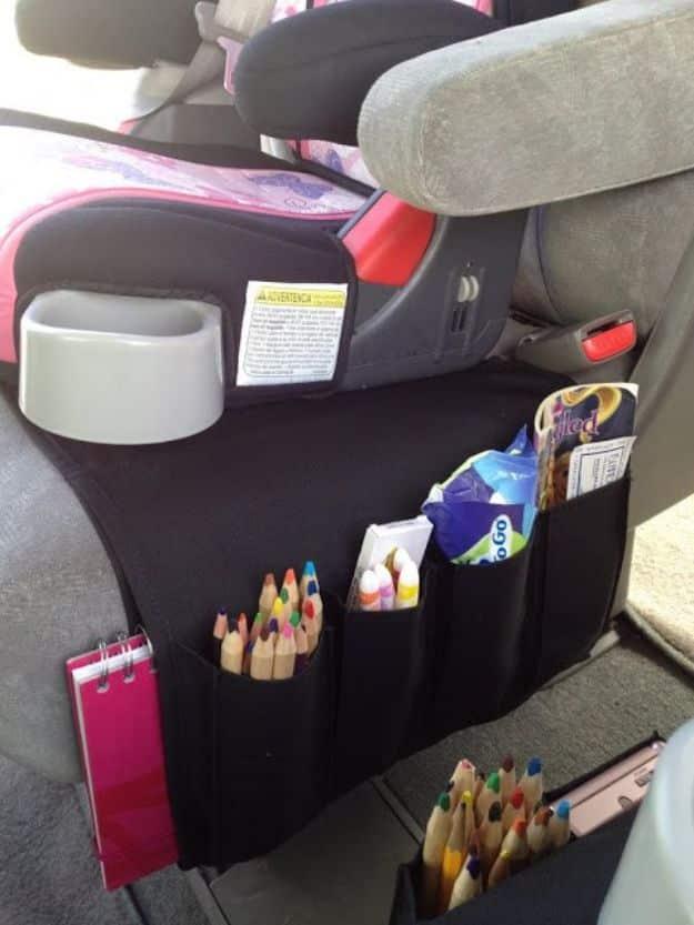 Flort car organizer for kids, a black seat back panel with pockets of colored pencils, crayons and snacks in a car