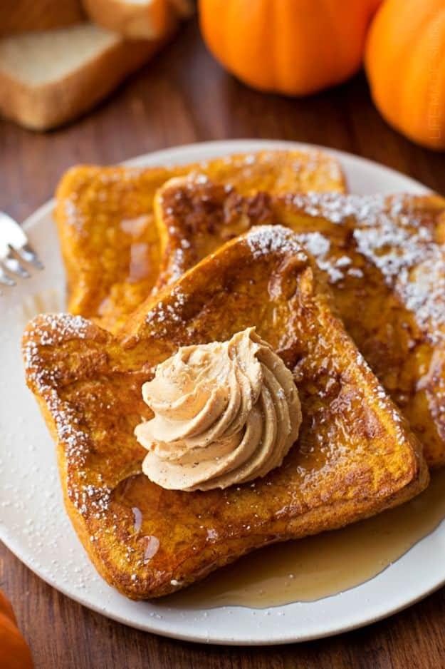 Plate of pumpkin french toast dusted with powdered sugar and topped with a swirl of whipped pumpkin butter