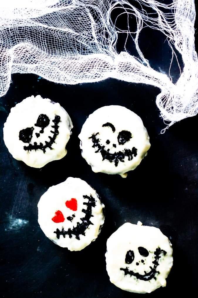 White chocolate covered Oreo cookies drawn with black Jack Skellington faces after the coating sets for Halloween