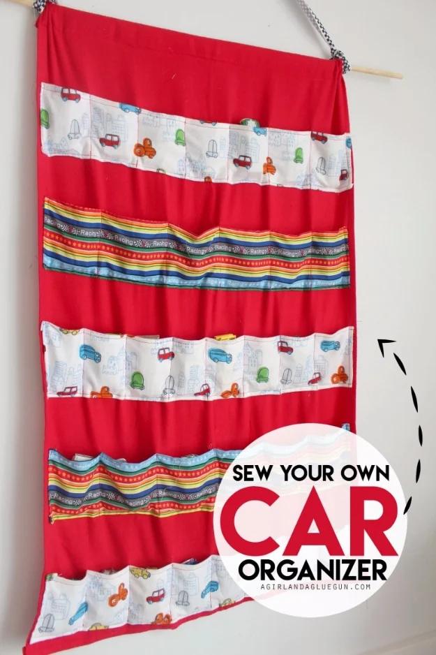 Sewing projects for boys car organizer in red fabric with rows of car print pockets hanging from a wooden dowel on a wall