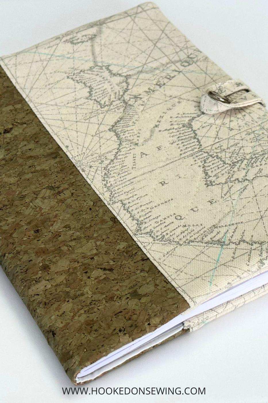 Fabric journal cover in cork and antique map print wrapped around a composition notebook, with a button loop closure