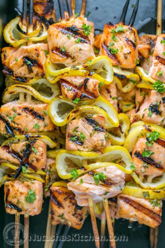 Grilled salmon skewers threaded with folded lemon slices and brushed with a garlic Dijon marinade for an outdoor barbecue