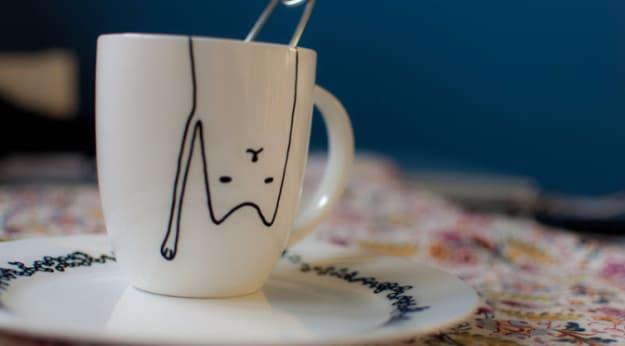DIY office gift: a mug decorated with a cat design for a coworker who loves cats and coffee both equally