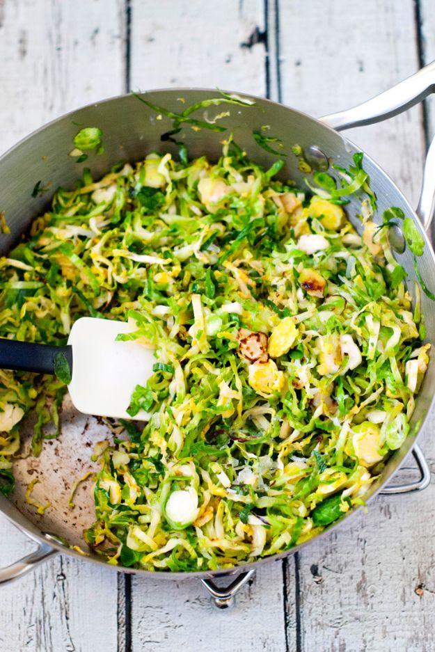 Shaved brussels sprout saute charred in a stainless steel skillet and turned over with a white spatula