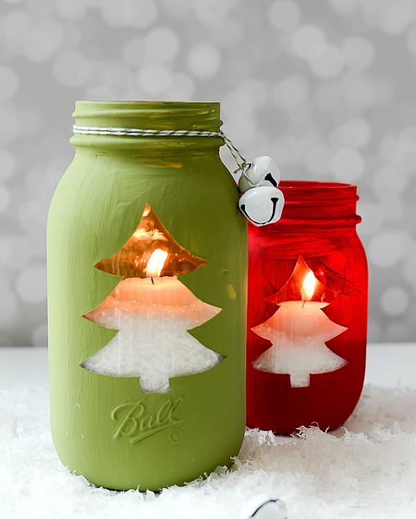 Red and green chalk painted mason jars with a clear Christmas tree cut out glowing from a tea light inside