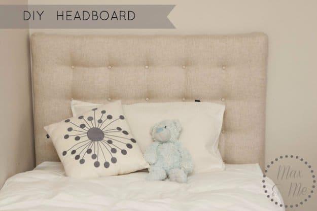 Linen and poplin headboard, a cream button tufted linen headboard above white pillows and a pale blue stuffed bear