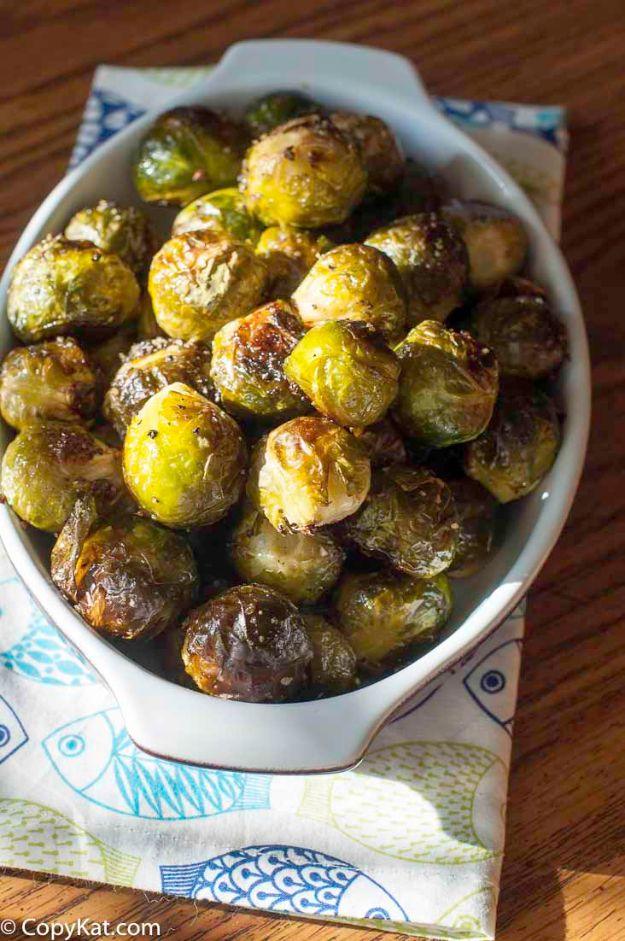 Red Lobster copycat roasted brussels sprouts, glossy with brown butter, piled in a white oval baking dish