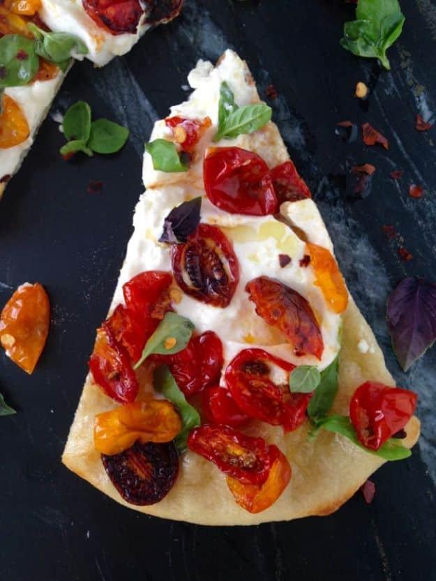 Rustic Italian pizza dough stretched thin on a floured surface with flour, olive oil and a dough ball