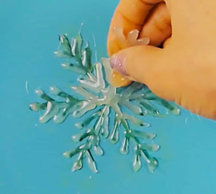 Learn to make a DIY Glue Gun Snowflake With Glitter