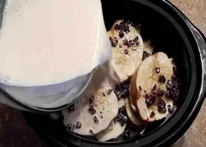 Adding the custard milk over the bread pudding