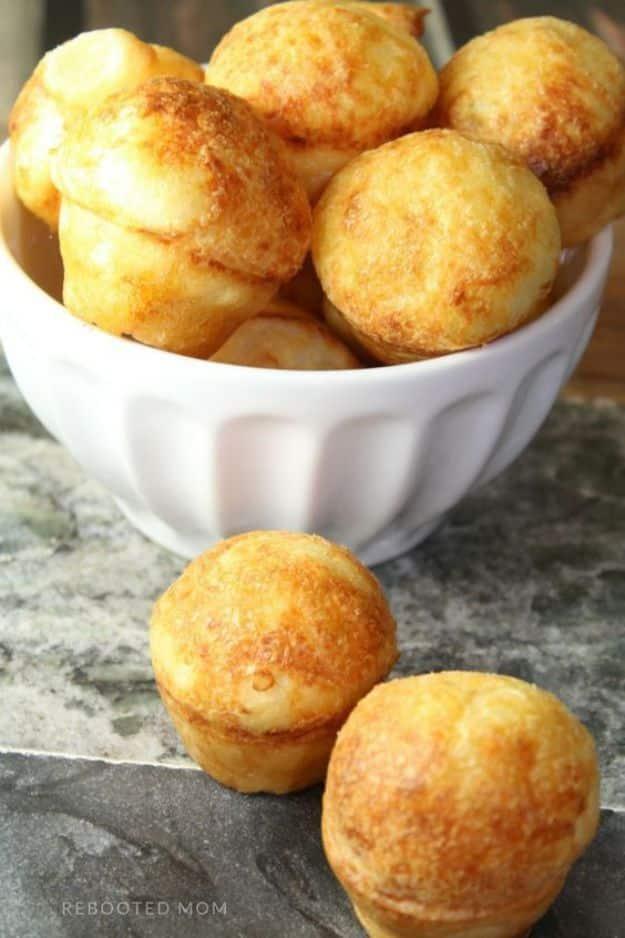 Brazilian cheese puffs, small golden pao de queijo rolls piled in a white bowl straight from the oven