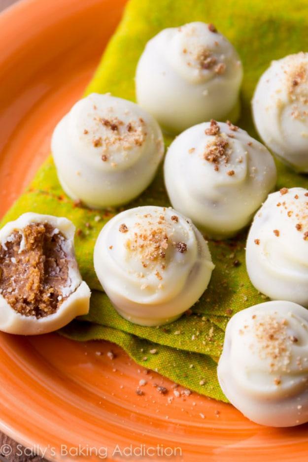 Pumpkin spice truffles dipped in white chocolate with graham crumbs on top, arranged on an orange plate