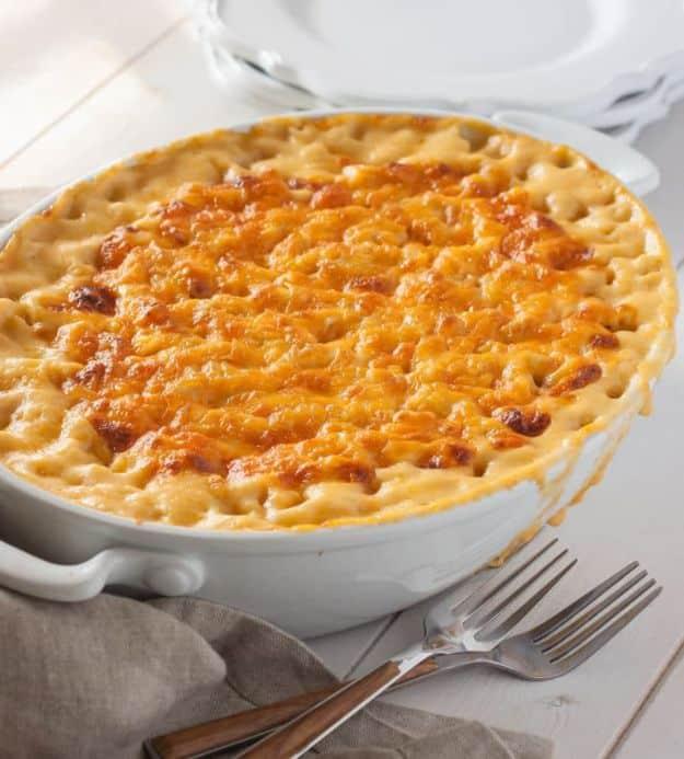 Southern style baked macaroni and cheese in a round white dish with a deeply browned extra sharp cheddar top