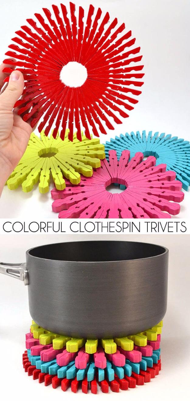Four circular trivets made from red, lime, pink and turquoise clothespins, with a grey saucepan resting on a stack