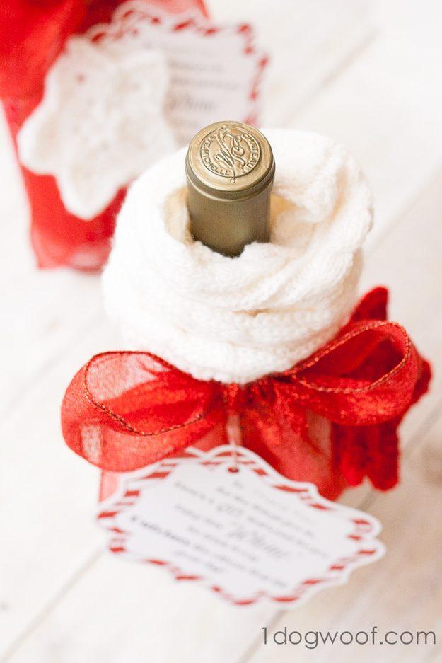 Wine bottle wrapped in a white knit sock, tied with a red organza bow and finished with a printed gift tag