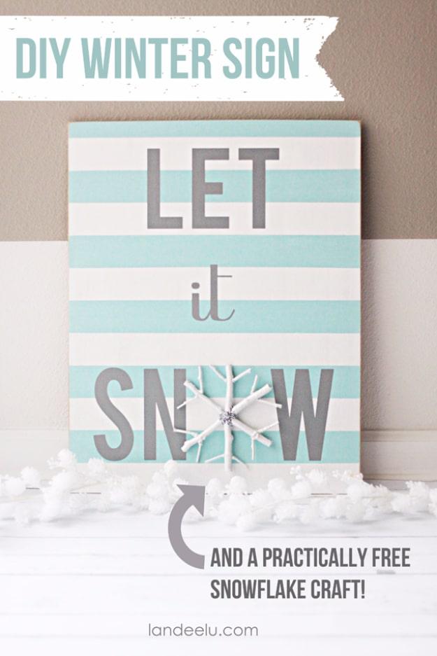 Striped aqua and white Let It Snow sign with a small white painted twig snowflake used as the letter O