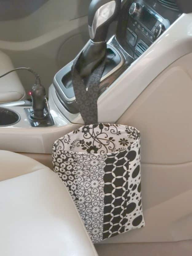 Easy car trash bag, a black and white patterned fabric caddy hanging from a gearstick in a cream car interior