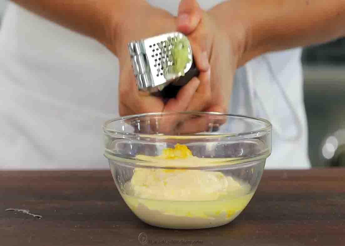 Adding crushed garlic to the crab cakes' dipping sauce
