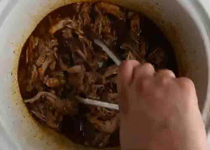 Mixing the pulled pork and the Dr. Pepper sauce