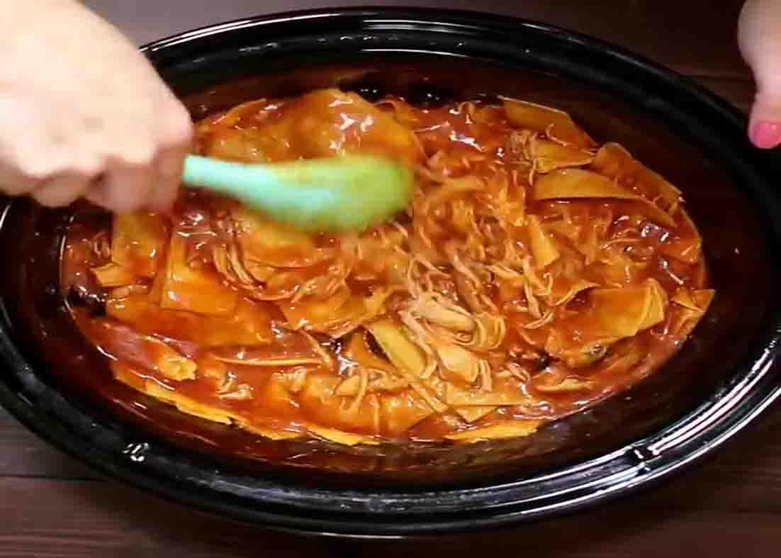 Stirring the chicken enchilada to combine all the ingredients