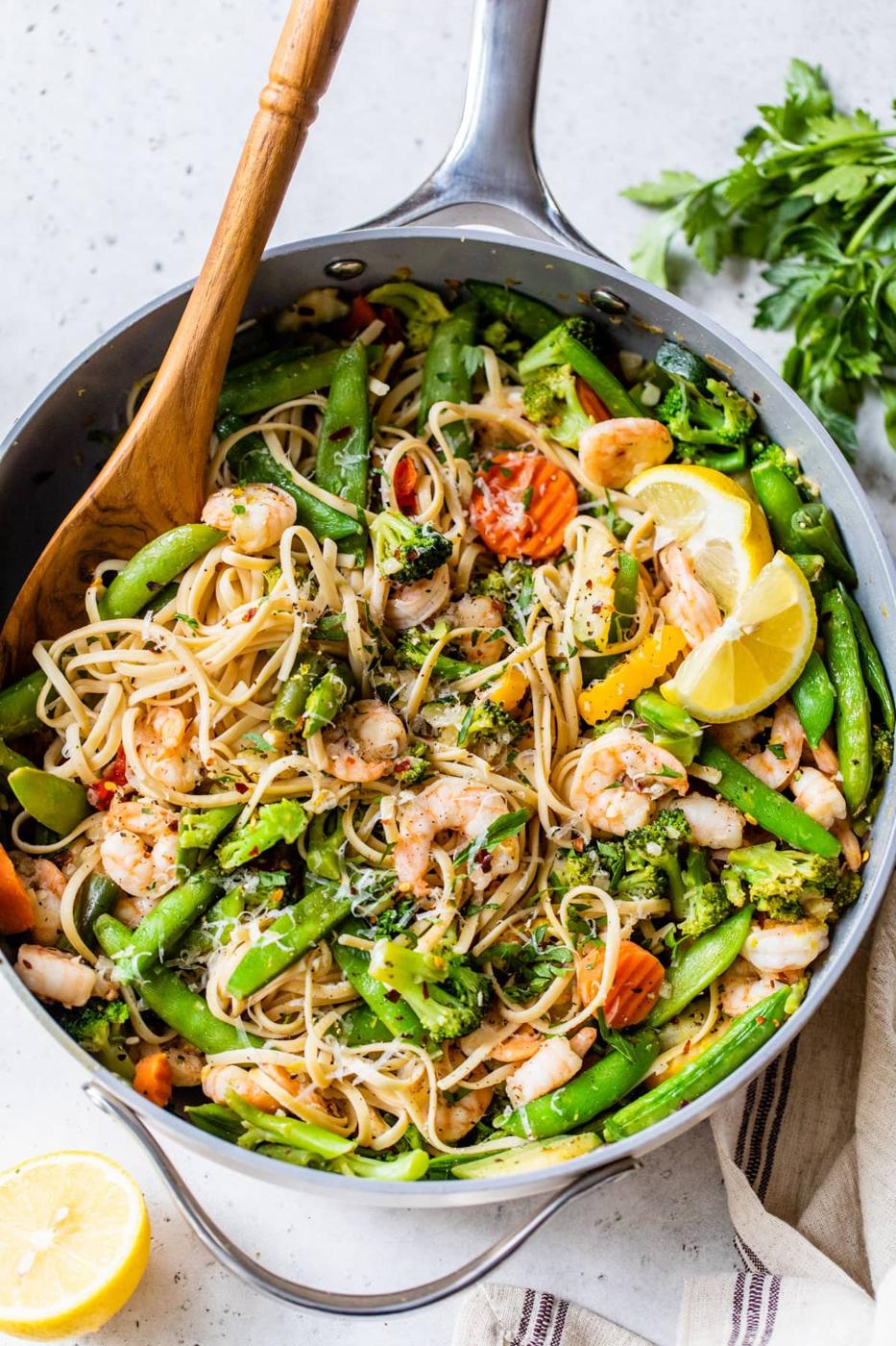 Garlic shrimp pasta with lemon in a skillet, shrimp and asparagus tossed through linguine with lemon slices