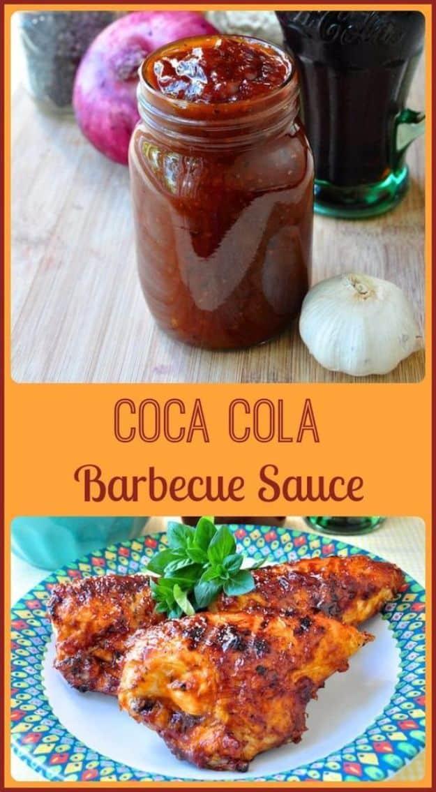Coca Cola barbecue sauce in a mason jar with garlic and onion beside it above a plate of sauced grilled chicken
