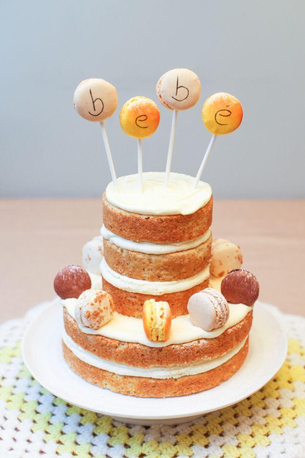 Two tier naked lemon cake with white filling, macarons around the tiers and macaron pops spelling bebe
