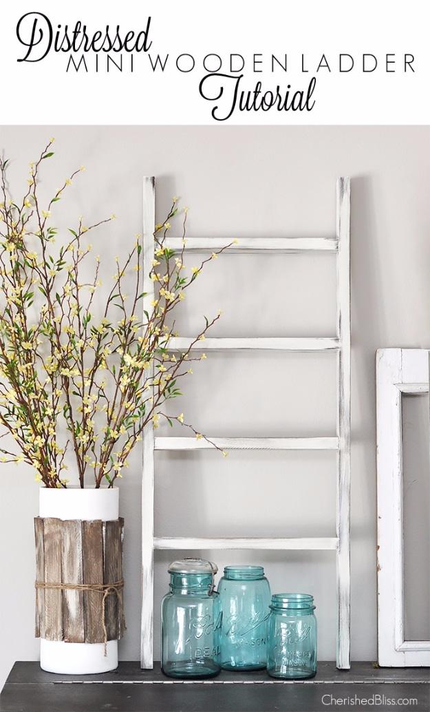 Distressed mini wooden ladder, a small white dry brushed ladder leaning beside blue mason jars and spring branches