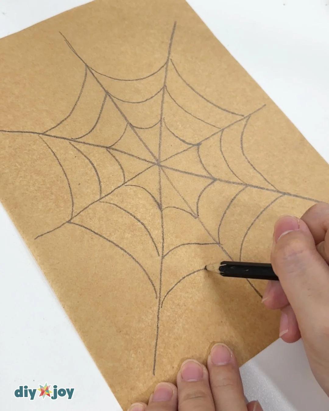 How To Make A Spider Web - a hand drawing the radial spokes and curved lines of a web pattern in pencil