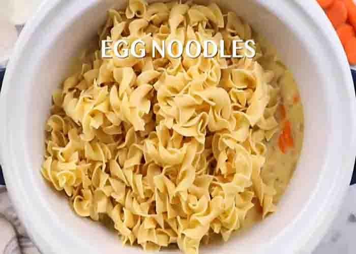 Adding the egg noodles to the slow cooker