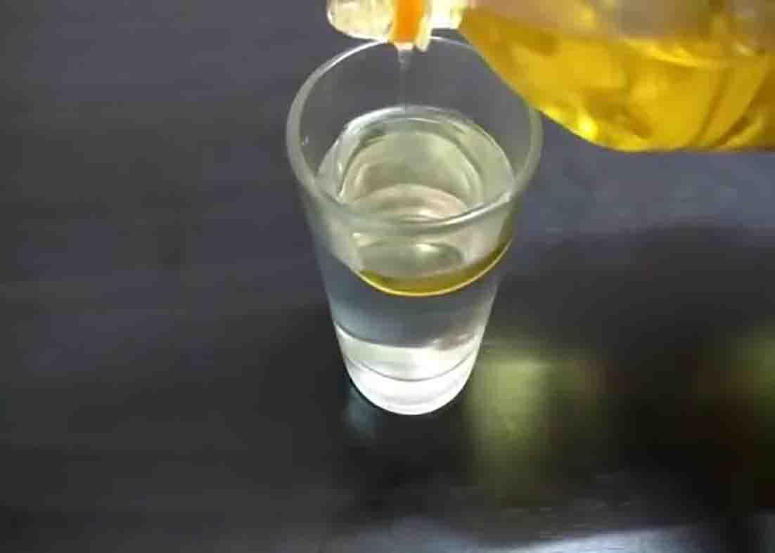 Pouring oil over the water to make the DIY water candles
