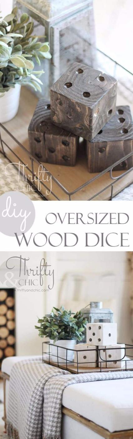 A pair of oversized wooden dice with painted black dots sit on an open shelf beside a stack of folded linens