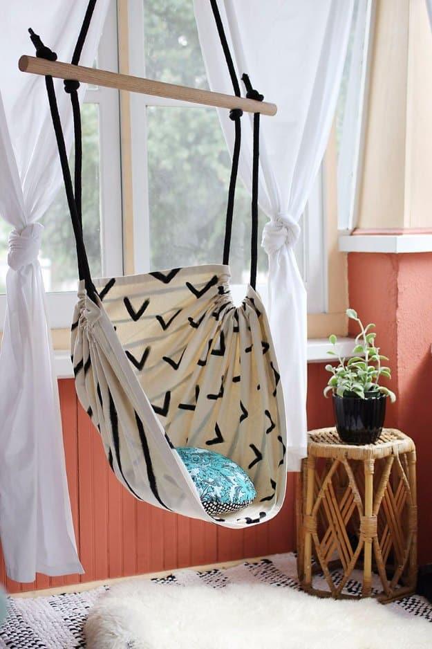 DIY hammock chair, a hanging canvas sling chair on a wooden dowel suspended by a window in a bright corner