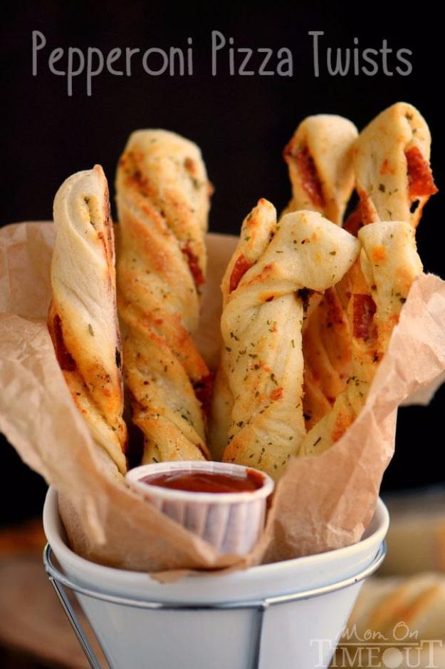 Pepperoni pizza twists, twisted strips of dough baked golden with parmesan and parsley on a baking sheet