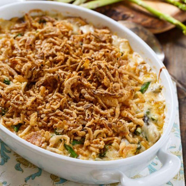Asparagus casserole in an oval dish with a creamy filling under a thick golden layer of french fried onions