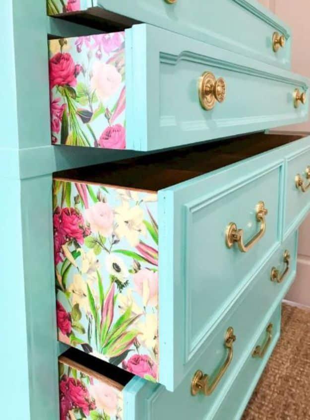 Teal painted dresser with bold pink and white floral paper on the drawer sides, shown with drawers open