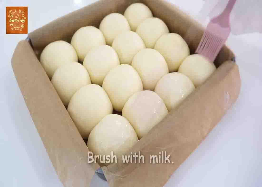 Brushing some milk over the dinner rolls