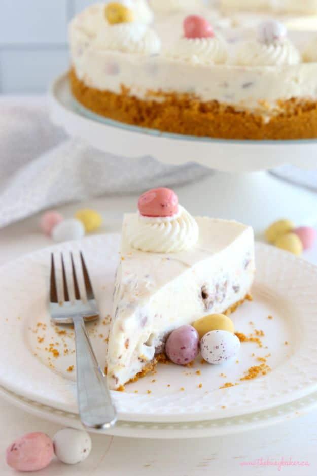 Easy no bake mini eggs cheesecake topped with crushed candy coated chocolate eggs and whipped cream, an easy no bake dessert