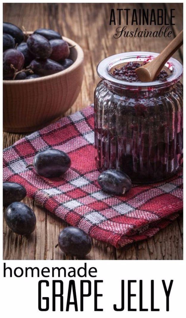 Homemade grape jelly in canning jars, deep purple and clear, with a butter knife and slices of white bread