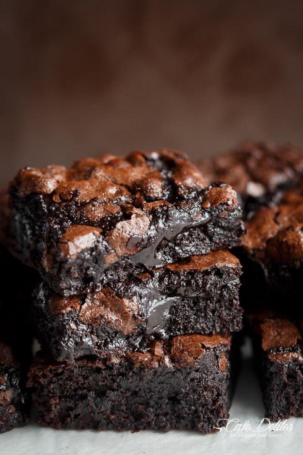 Best fudgy cocoa brownies stacked on parchment paper with a crackly top and a soft gooey chocolate center