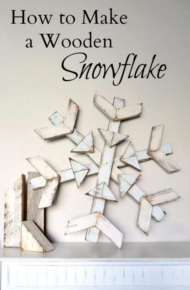 Large whitewashed wooden snowflake built from distressed boards hanging above a mantel, on a typeset graphic