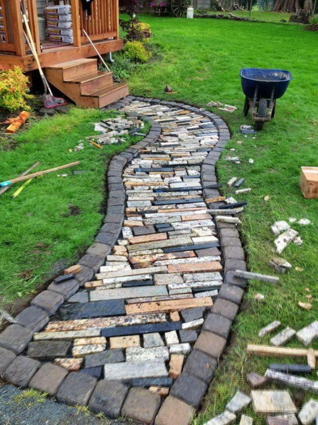 Curved walkway made from recycled granite countertop offcuts edged with dark cobble pavers in a lawn