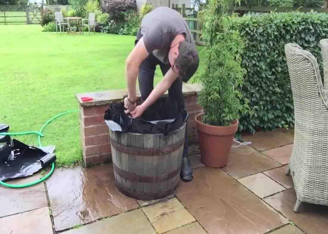 Putting the pond liner within the half barrel pond