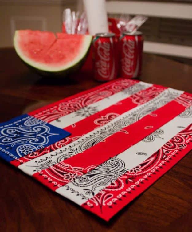 Flag style bandana placemat in red, white and blue on a wood table with a watermelon slice and red soda cans
