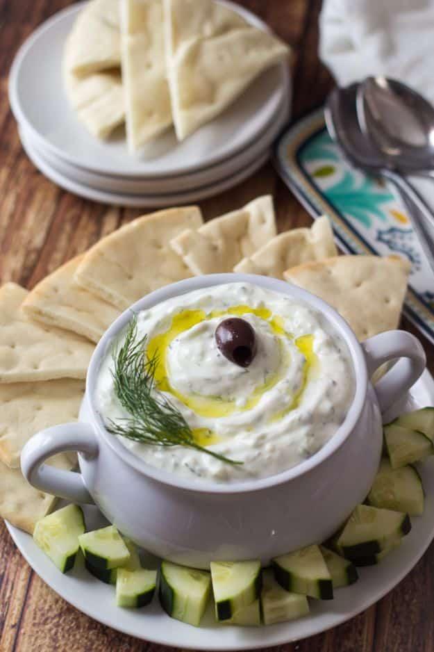 Authentic Greek tzatziki in a bowl with grated cucumber, fresh dill and a drizzle of olive oil on top