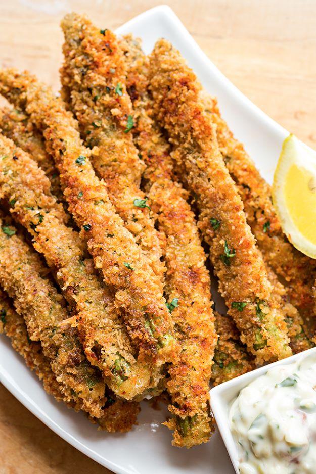 Parmesan asparagus spears on a white plate, golden breaded spears with a lemon wedge and bowl of aioli