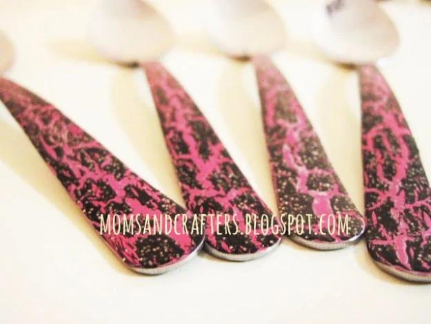 Enameled spoons, four steel spoons with handles lacquered in hot pink and black crackle nail polish on white
