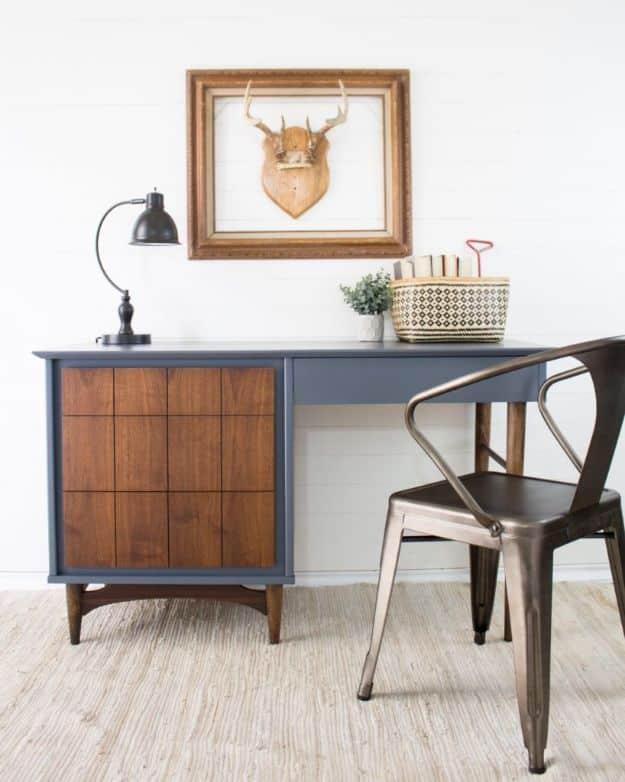 Slate blue painted midcentury desk with bare stained wood drawer fronts and legs, black task lamp and metal chair