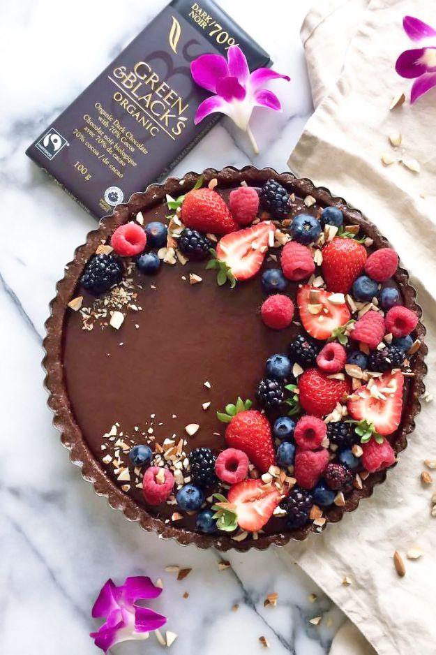 No bake chocolate tart with a date and almond crust, dark chocolate filling and fresh berries on top